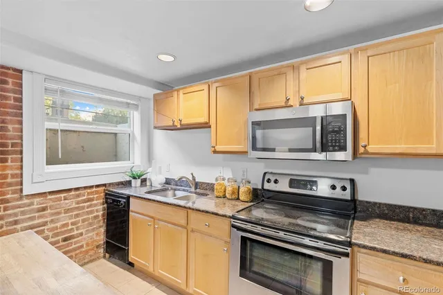 a kitchen with stainless steel appliances a stove sink and microwave