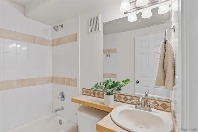 a bathroom with a sink a mirror a bathtub and a shower