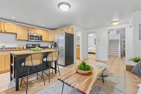 a kitchen with a table chairs refrigerator and microwave