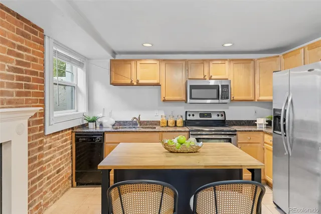 a kitchen with a refrigerator a stove a sink dishwasher and microwave with wooden floor