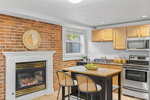 a kitchen with a stove a sink cabinets and a fireplace