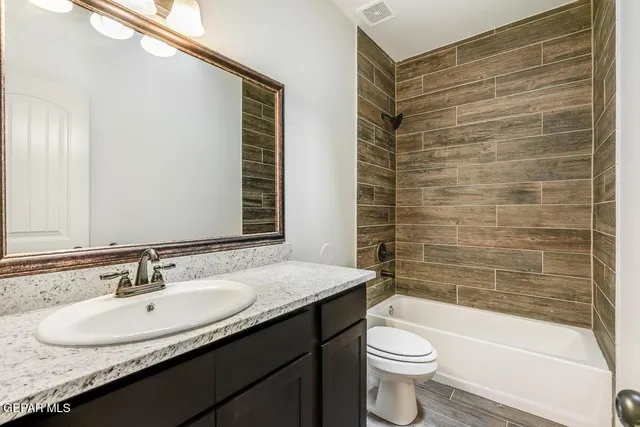 a bathroom with a granite countertop sink toilet and shower