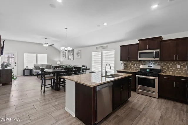 a kitchen with lots of counter top space a sink appliances and cabinets