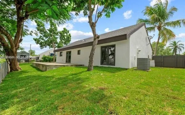 a view of a house with backyard and a tree