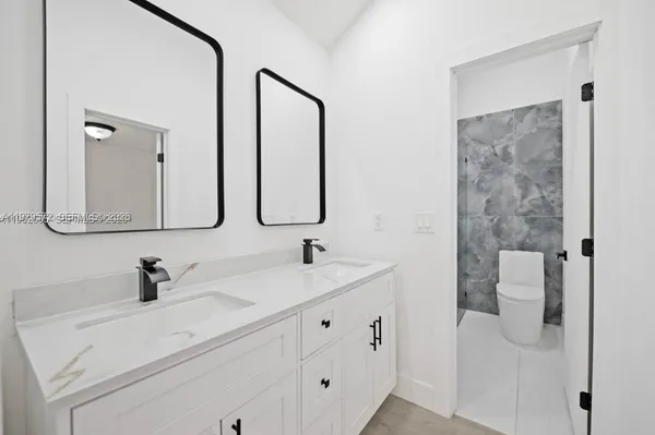 a bathroom with a double vanity sink mirror and