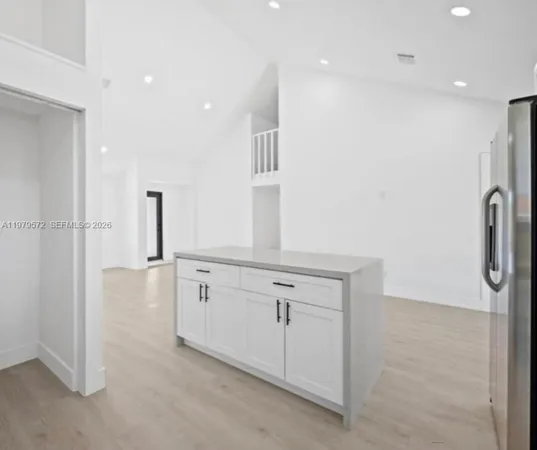 a view of a kitchen with white cabinets