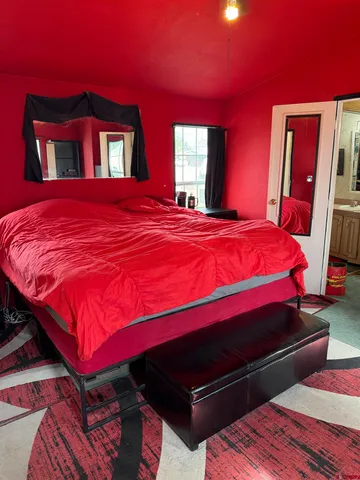 a large bed sitting in a bedroom next to a window