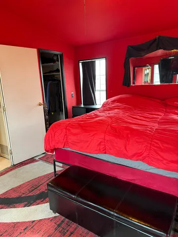 a bedroom with a bed and a flat screen tv