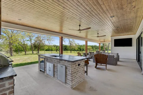 a living room with patio furniture and a large window