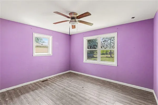 a view of a big room with wooden floor and windows