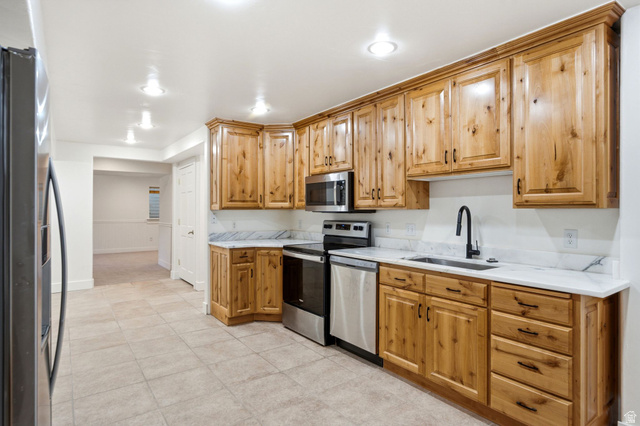 3027 Homestead Road Park City, UT 84098 - Photo 41 of 62 Spacious kitchen featuring natural wood cabinetry, stainless steel appliances, a matte black faucet, white countertops, and tile flooring