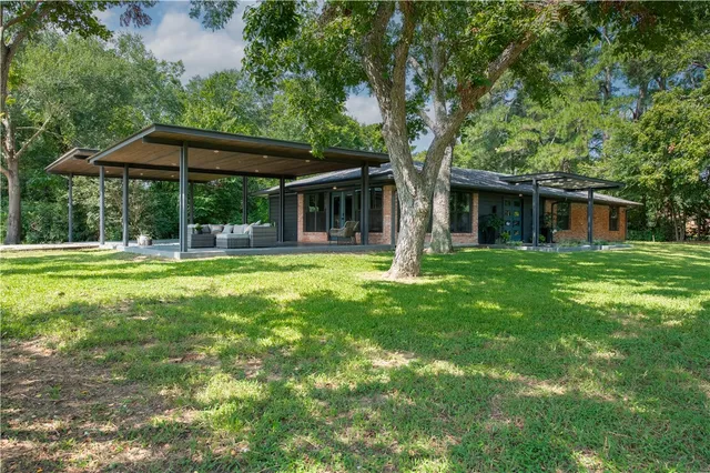 a front view of house with yard barbeque and outdoor seating