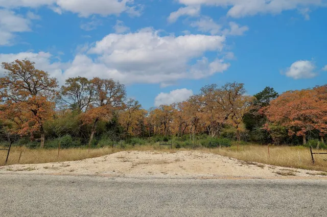 a view of dirt road with a building in the background