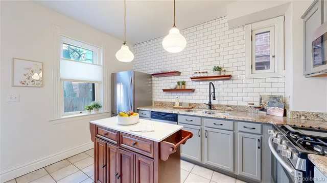a kitchen with a stove a sink a window and wooden floor