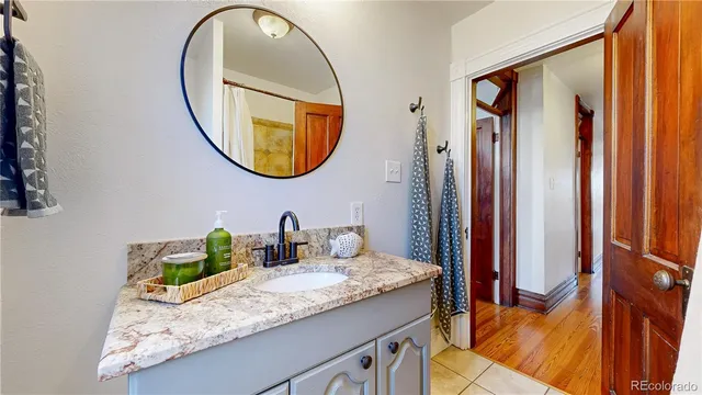 a bathroom with a granite countertop sink and a mirror
