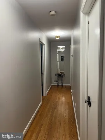 a view of a hallway with wooden floor