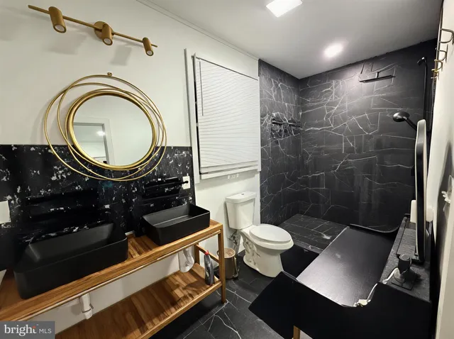 a bathroom with a sink mirror vanity and toilet