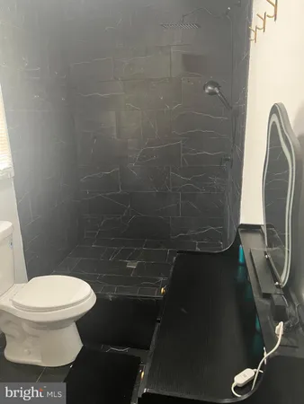 a white toilet sitting next to a shower