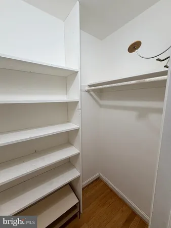 a view of walk in closet with empty racks