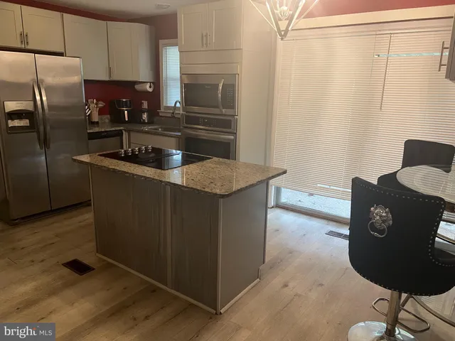 a kitchen with granite countertop a refrigerator and a stove