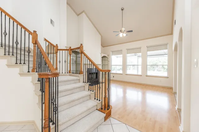 a view of staircase with wooden floor and fan