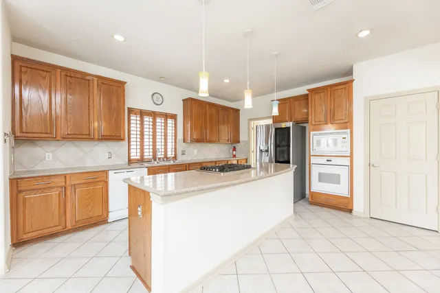 a kitchen with stainless steel appliances granite countertop a refrigerator and a stove top oven