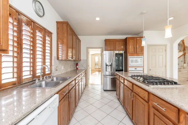 a kitchen with stainless steel appliances granite countertop a sink stove and cabinets