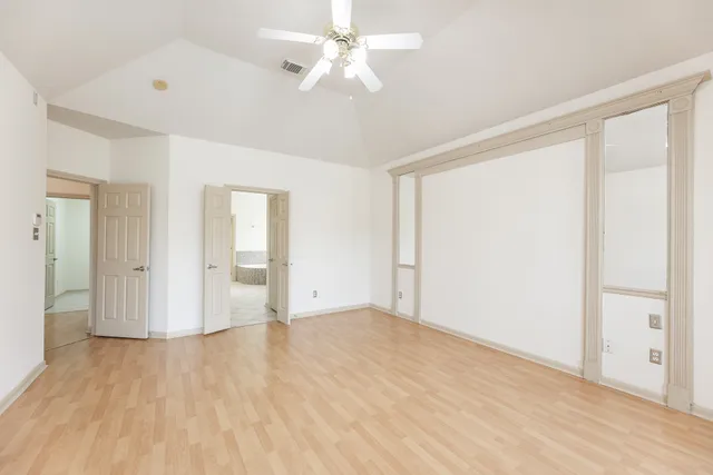 a view of an empty room with wooden floor