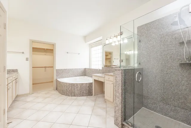 a bathroom with a bathtub shower sink and mirror