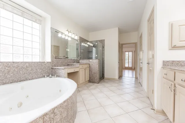a spacious bathroom with a tub sink and mirror
