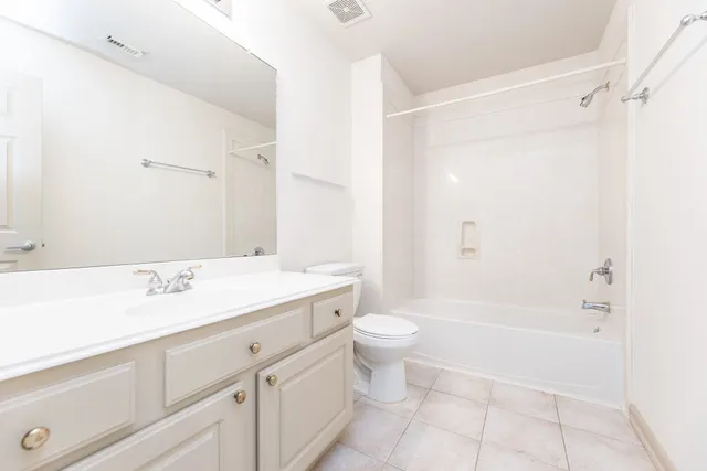a bathroom with a granite countertop sink a toilet and a bathtub