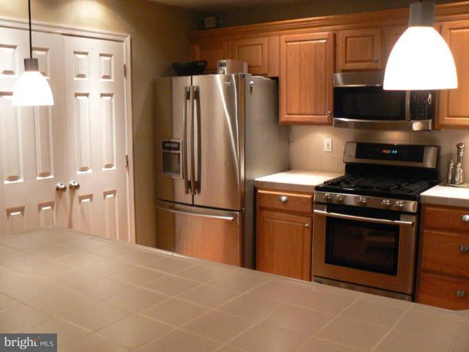 44886 Mallard Place Callaway, MD 20620 - Photo 6 of 30 a kitchen with stainless steel appliances a refrigerator a stove a microwave and cabinets