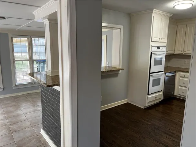 a view of kitchen with wooden floor and electronic appliances