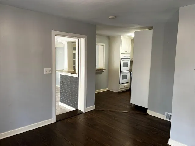 an empty room with wooden floor and entrance
