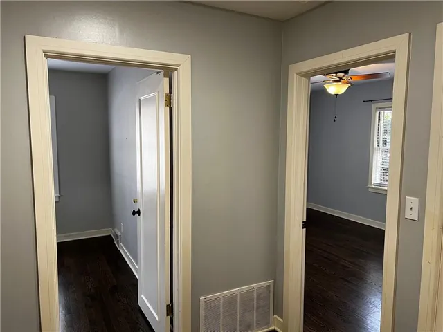 a view of a hallway with wooden floor and stairs