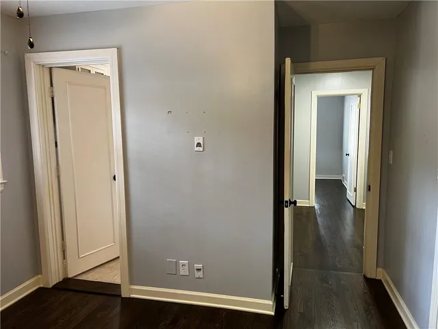 an empty room with wooden floor and closet