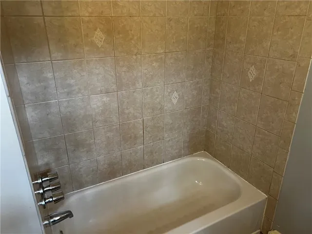 a bath tub sitting next to a white sink and a shower