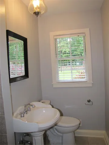 a bathroom with a sink a toilet and a window