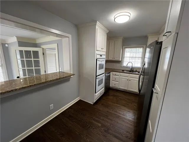 a kitchen with cabinets and wooden floor