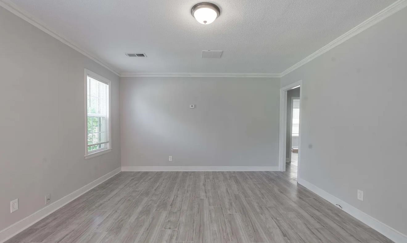 1009 McEvers Road Memphis, TN 38111 - Photo 5 of 6 an empty room with wooden floor and windows