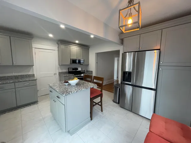 a kitchen with stainless steel appliances granite countertop a refrigerator sink and stove