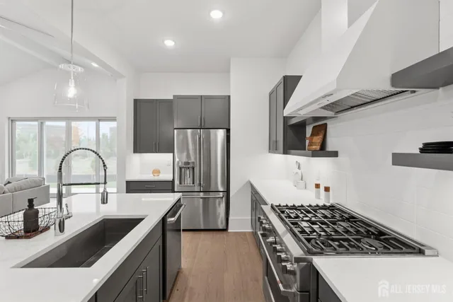 a large white kitchen with a large stove a sink a refrigerator and a fireplace