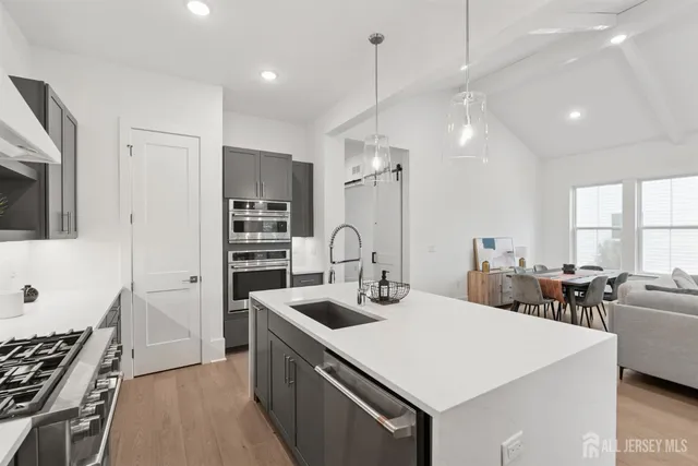 a kitchen with stainless steel appliances a stove a sink island and a refrigerator