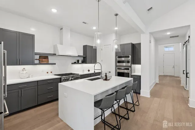 a kitchen with stainless steel appliances a sink stove and cabinets