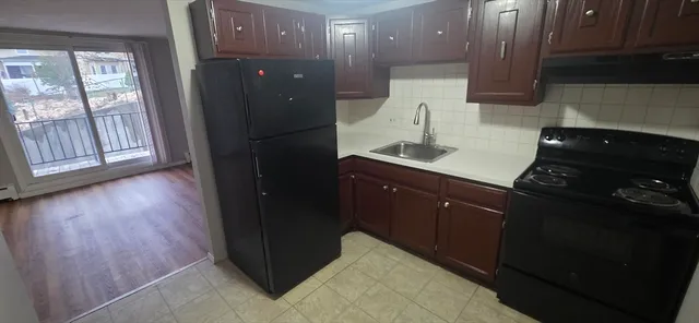 a kitchen with a sink and wooden floor