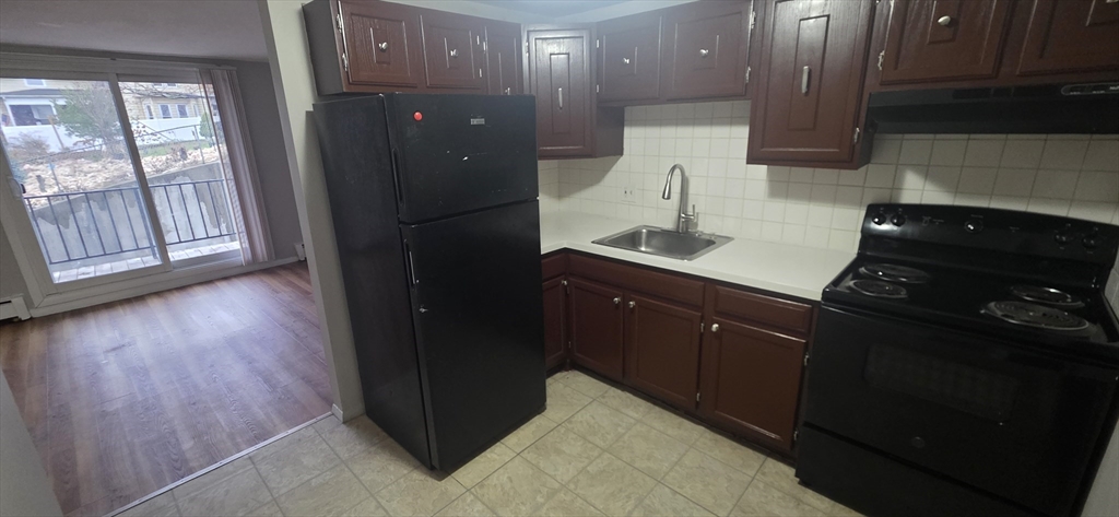 a kitchen with a sink and wooden floor