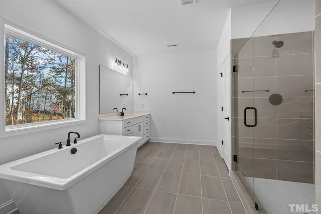 a bathroom with a sink double vanity mirror and tub