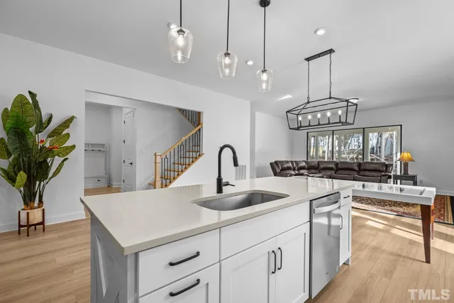 a kitchen with stainless steel appliances sink stove refrigerator and cabinets