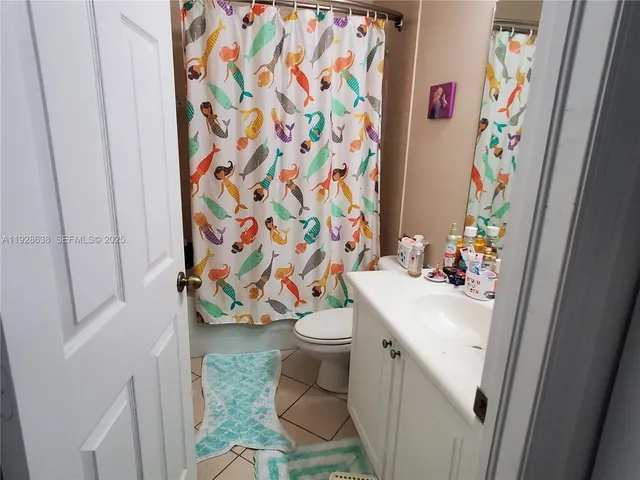a bathroom with a sink a toilet and shower curtain