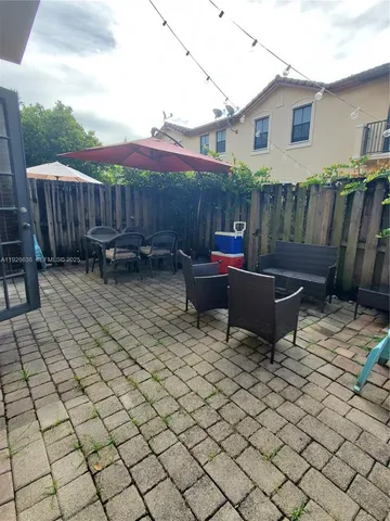 a backyard of a house with barbeque oven table and chairs